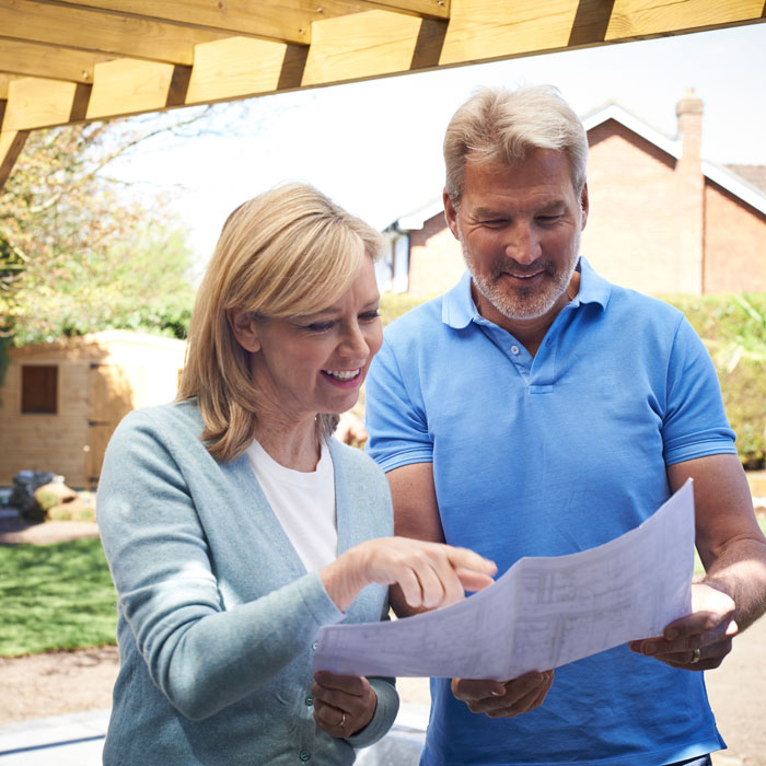 woman looking at landscape plans with man